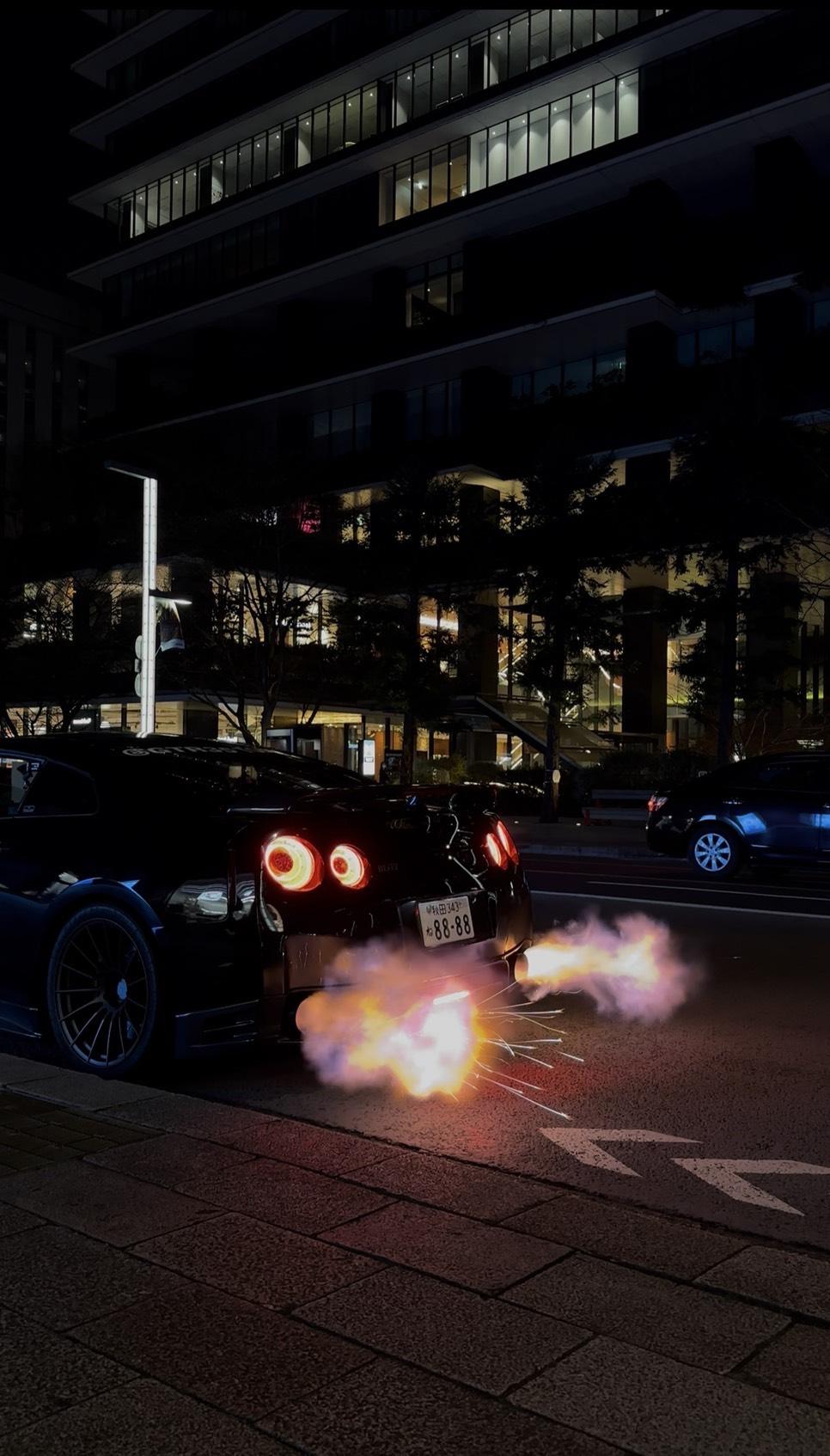 Nissan GT-R shooting flames on Tokyo streets at night